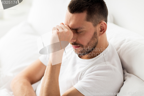 Image of close up of stressed man in bed at home