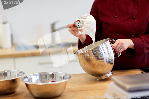 Image of chef with whisk and whipped egg whites at kitchen