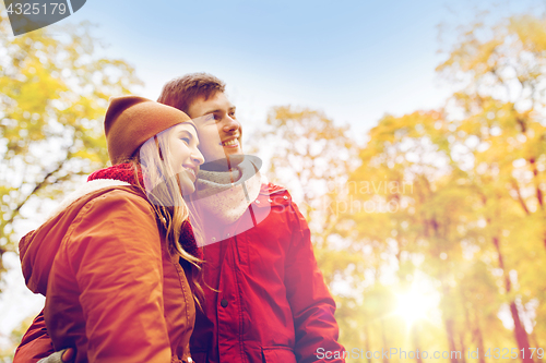 Image of happy young couple walking in autumn park