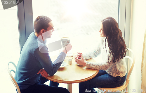 Image of happy couple drinking tea and coffee at cafe