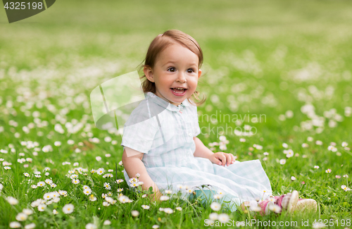 Image of happy baby girl on green summer field