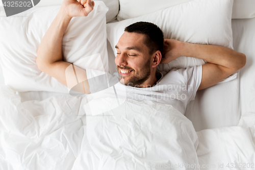 Image of man lying in bed at home