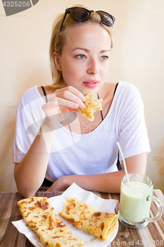 Image of Woman eating traditional moroccan breakfast in coffee shop.