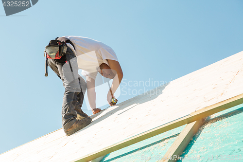 Image of Builder at work with wooden roof construction.