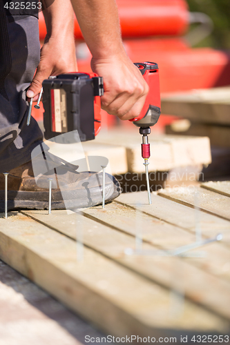Image of Carpenter working with an electric screwdriver.