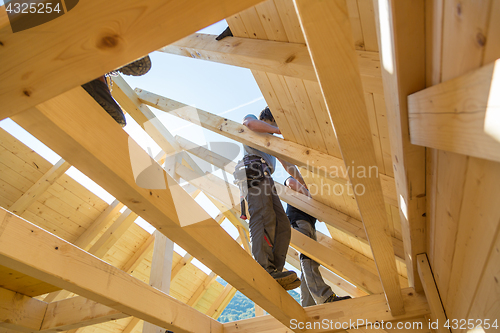 Image of Builders at work with wooden roof construction.