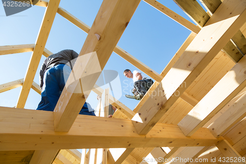 Image of Builders at work with wooden roof construction.