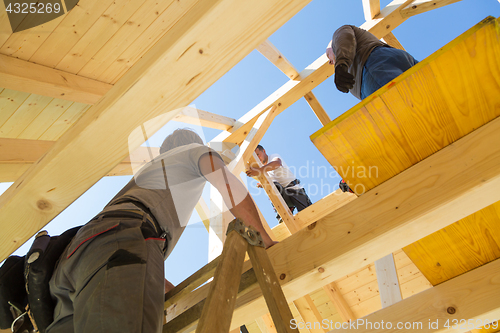 Image of Builders at work with wooden roof construction.