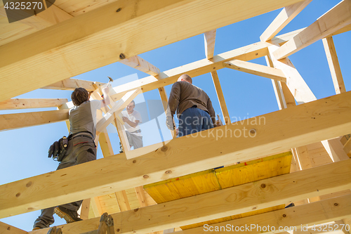 Image of Builders at work with wooden roof construction.