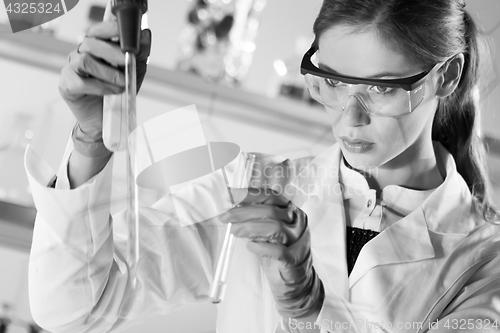 Image of Young scientist pipetting in life science laboratory.