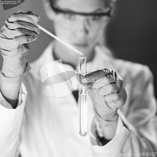 Image of Young scientist pipetting in life science laboratory.