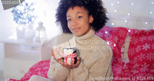 Image of Smiling woman enjoying a cup of Christmas coffee