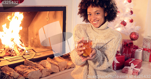 Image of Happy young woman relaxing at Christmas