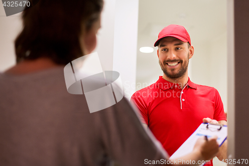 Image of deliveryman with clipboard at customer home