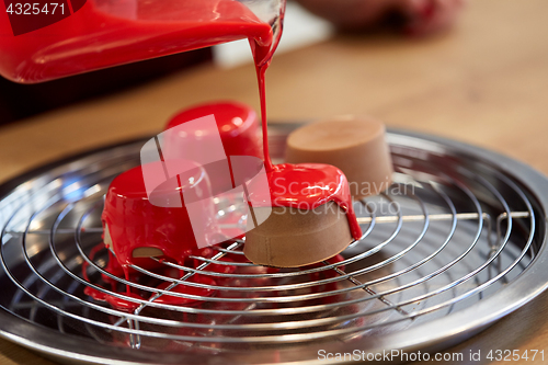 Image of jug pouring glaze to cakes at pastry shop