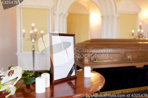 Image of photo frame and coffin at funeral in church