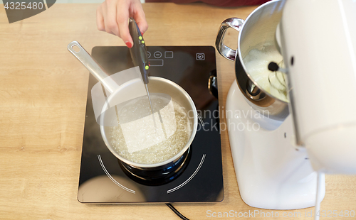 Image of chef measuring temperature in syrup at kitchen