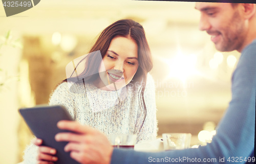 Image of happy couple with tablet pc drinking tea at cafe