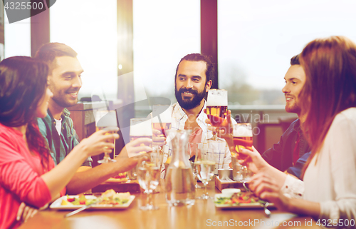 Image of friends dining and drinking beer at restaurant