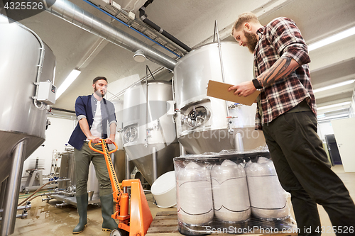 Image of men with beer kegs and clipboard at craft brewery