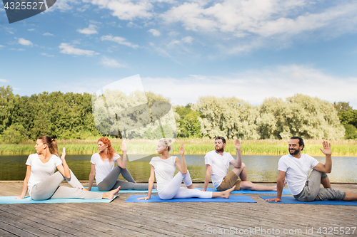 Image of people making yoga in half lord of the fishes pose