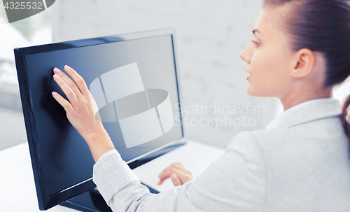 Image of smiling businesswoman with touchscreen in office