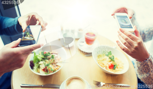 Image of close up of couple picturing food by smartphone