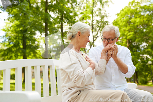 Image of happy senior couple hugging in city park