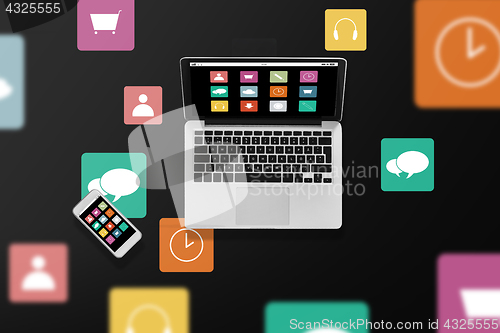 Image of laptop computer with menu icons and smartphone