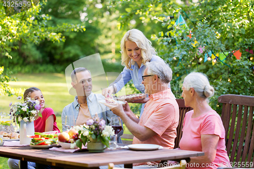 Image of happy family having dinner or summer garden party