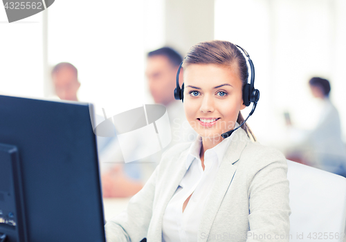 Image of helpline operator with headphones in call centre