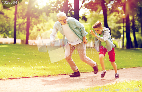 Image of grandfather and grandson racing at summer park