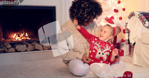 Image of Pretty little girl plays with her mothers hair