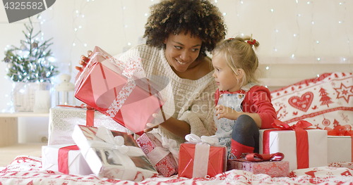Image of Mother showing child a large Christmas gift