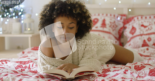 Image of Calm beautiful African woman reading in bed