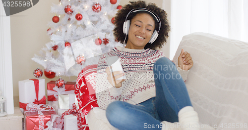 Image of Young girl relaxing listening to Christmas music