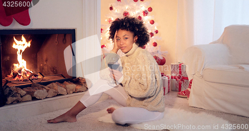 Image of Woman in leggings and sweater sits by white tree