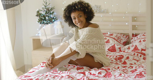 Image of Sexy young woman relaxing on her bed at Christmas