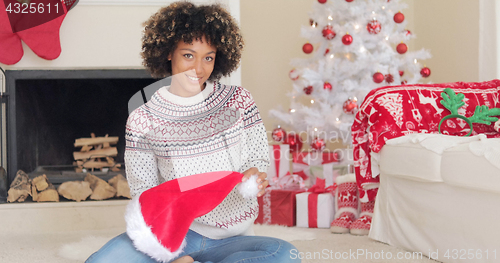 Image of Smiling young woman holding a Santa hat