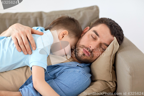 Image of happy father and son sleeping on sofa at home