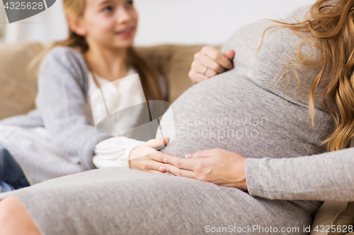 Image of close up of pregnant woman and girl at home