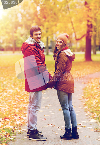 Image of happy young couple walking in autumn park