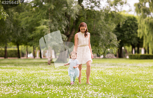 Image of mother with baby girl walking at summer park
