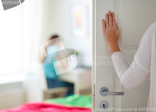 Image of mother hand opening door to girl room