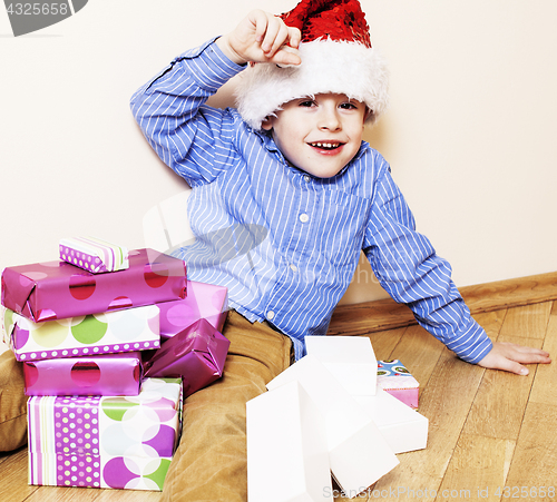 Image of little cute boy with Christmas gifts at home. close up emotional