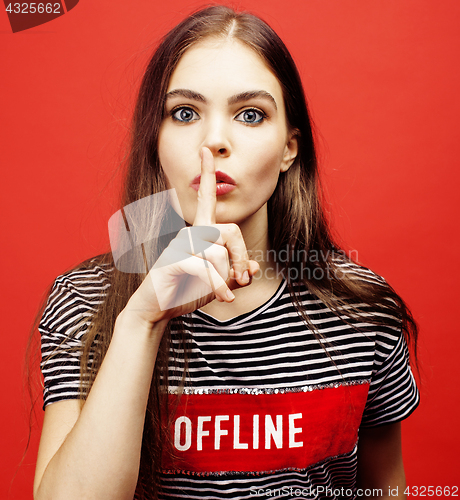 Image of young pretty emitonal posing teenage girl on bright red background, happy smiling lifestyle people concept 