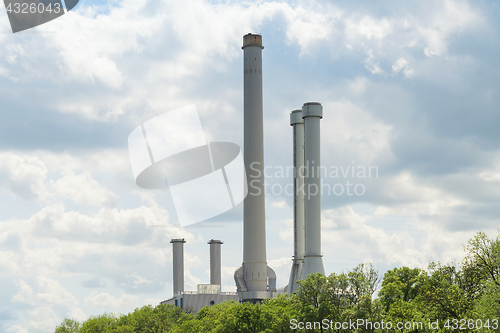 Image of High industrial chimneys over green trees in forest