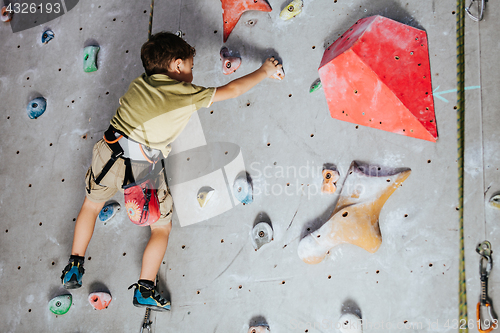 Image of little boy climbing a rock wall indoor