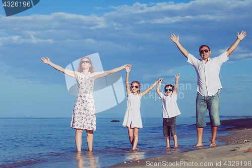 Image of Happy family walking on the beach at the day time.