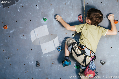 Image of little boy climbing a rock wall indoor